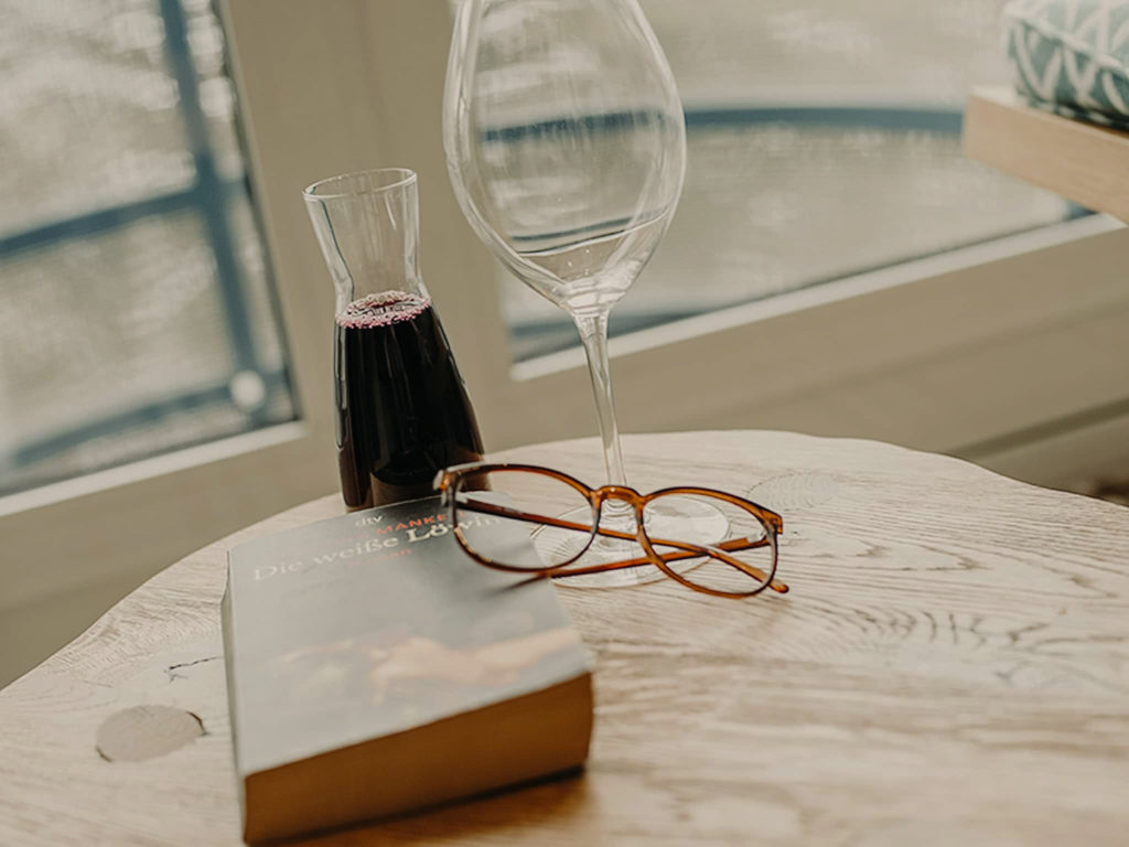 Tisch mit Buch und Wein Schlafzimmer Hotel Sendlhofer's Bad Hofgastein