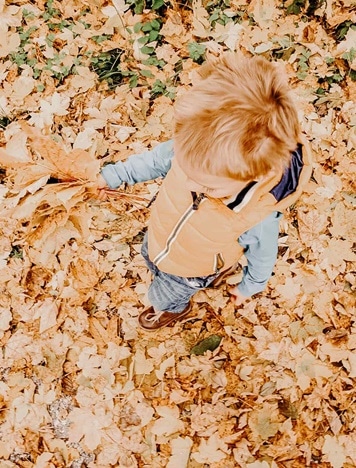 Kind spielt im Laub