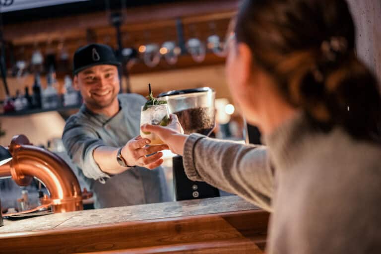 Lukes Wohnzimmer Bad Hofgastein Barkeeper überreicht Drink