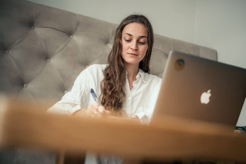 Frau beim Arbeiten am Laptop im Hotelzimmer