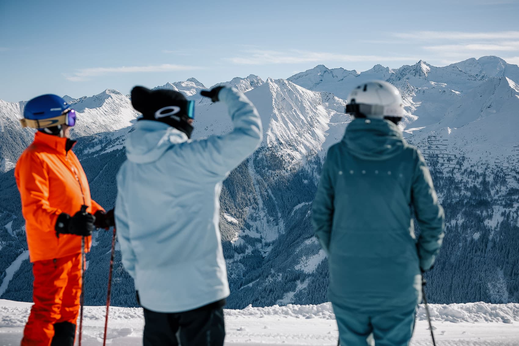 Familie beim Skifahren mit Blick über die verschneite Bergwelt
