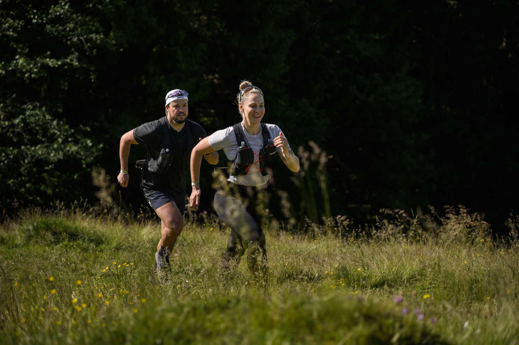 Frau und Mann rennen durch die Wiesen von Gastein