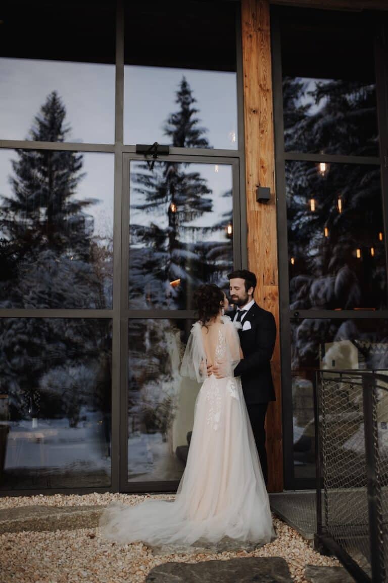 Brautpaar im Winter vor Glasfront in LUKE'S Wohnzimmer