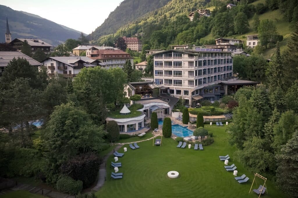 Drohnenaufnahme vom Hotel mit Garten, Pool und Bad Hofgastein im Hintergrund
