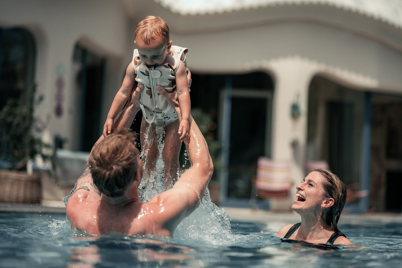 Vater, Mutter und Kind beim Spielen im Wasser