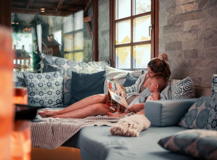 Frau mit Kind beim Lesen im Wellnessbereich
